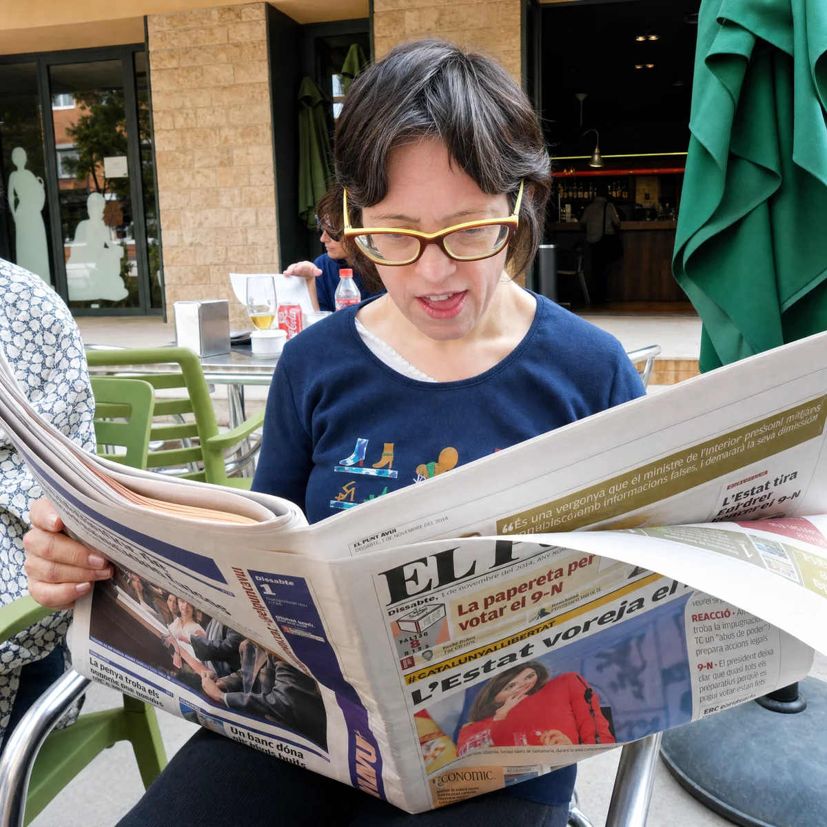 Dona llegint el diari en una terrassa